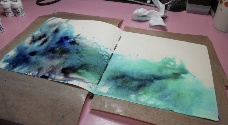 Spritzed Brusho Powders in Art Journal with additional water