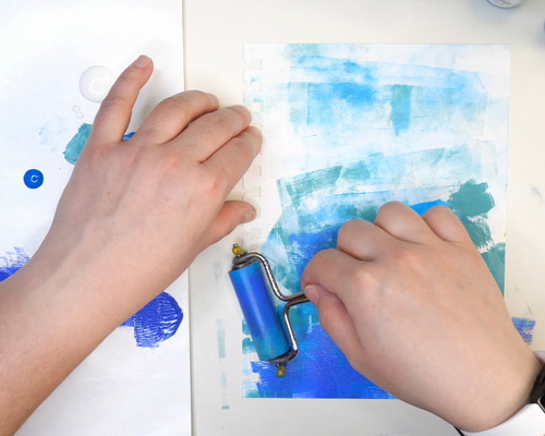 Using a brayer to add acrylic paint to an art journal page