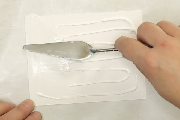 Adding aluminum foil to paper by adding glue with a palette knife to cardstock
