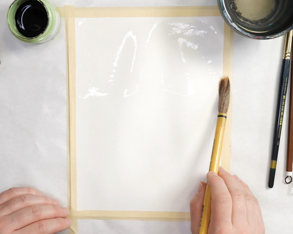 Adding water to watercolor paper for background wash
