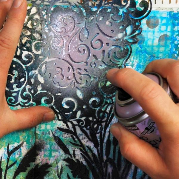 Adding Lilac Spray Paint Through Stencil on Collage Art Journal Page