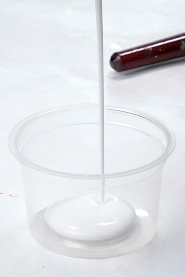 Pouring liquitex matte medium into a cup