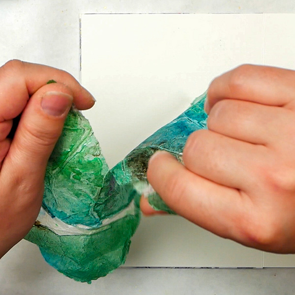 Tearing painted tissue paper for creating a collage page in an art journal