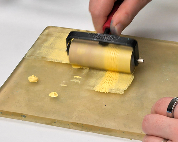 Spreading paint with a brayer on a gel plate