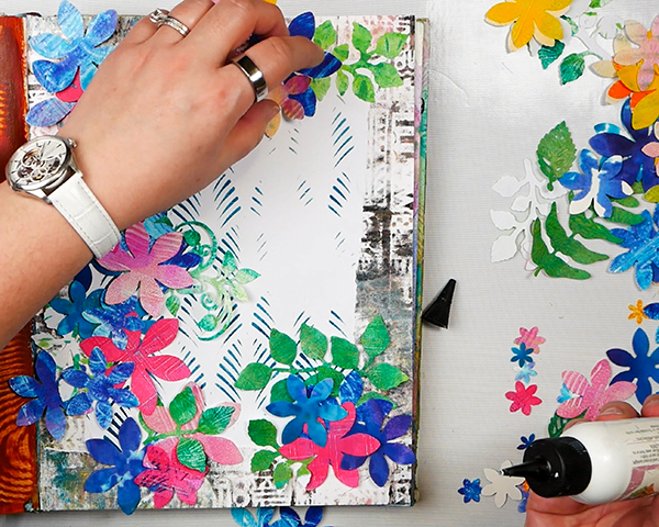 Gluing in gelli printings flowers to art journal page