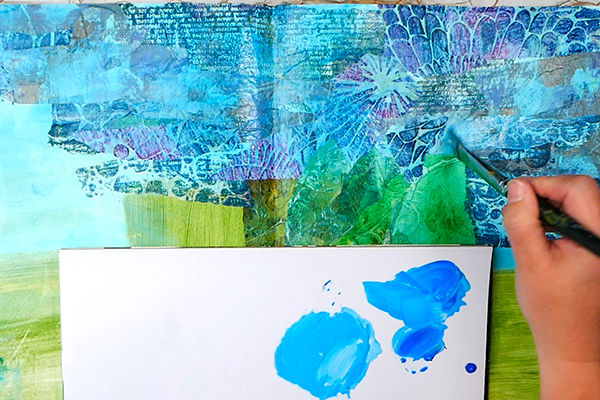 Adding in acrylic paint washes onto textured collage art journal page