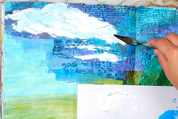 Palette knife painting clouds onto textured collage