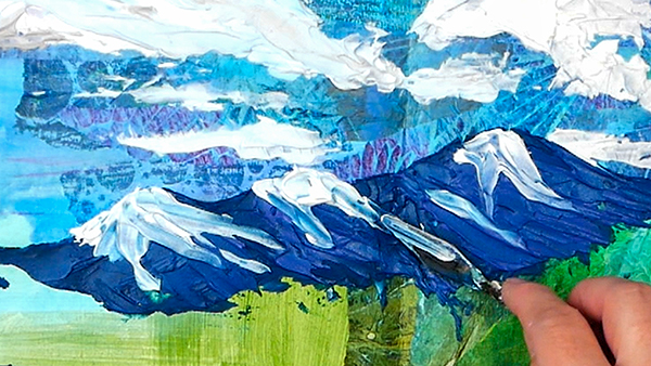 Palette knife painting mountains onto textured collage