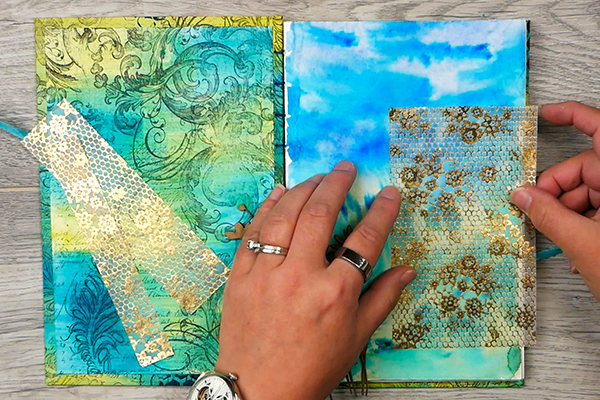 Adding vellum to a watercolor background in a handmade art journal