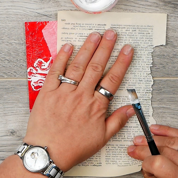 Removing acrylic paint from collage surface using dictionary page for blotting