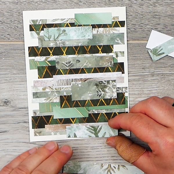 Adding final touches to abstract holiday card made from paper scraps