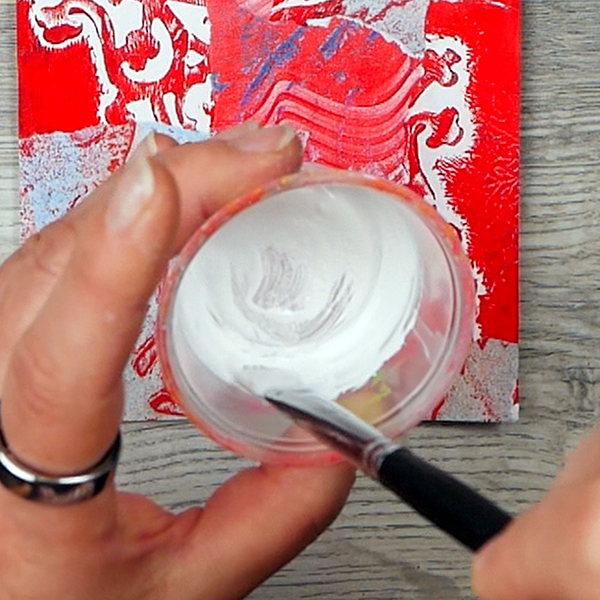 Mixing white paint with water to create a wash